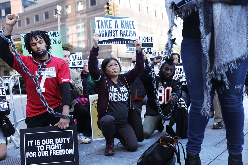 A coalition of advocacy groups “take a knee” outside a hotel where quarterly NFL league meetings are held Oct. 17, 2017, in New York City. (Spencer Platt/Getty Images)
